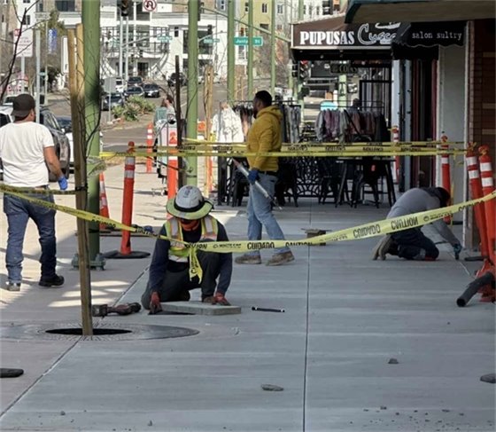 Construction along Grand Avenue: Crew working on final sidewalk improvements. 